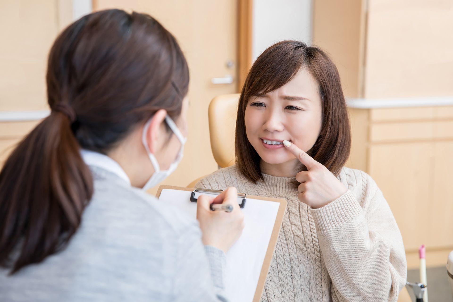 歯科衛生士に痛みを訴える女性